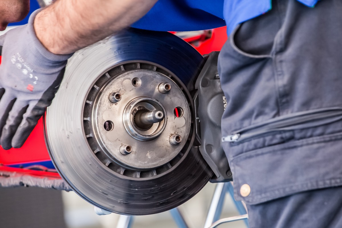 mechanic repairing brakes on a vehicle