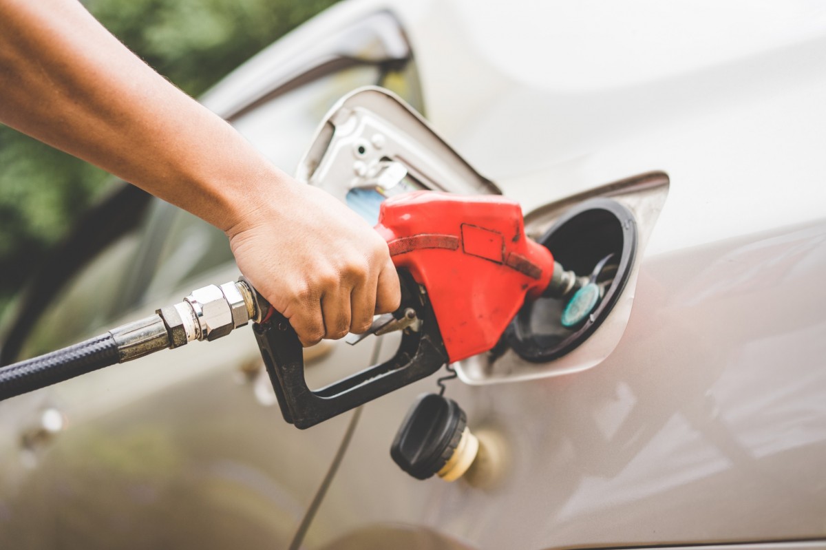 person putting fuel into vehicle 